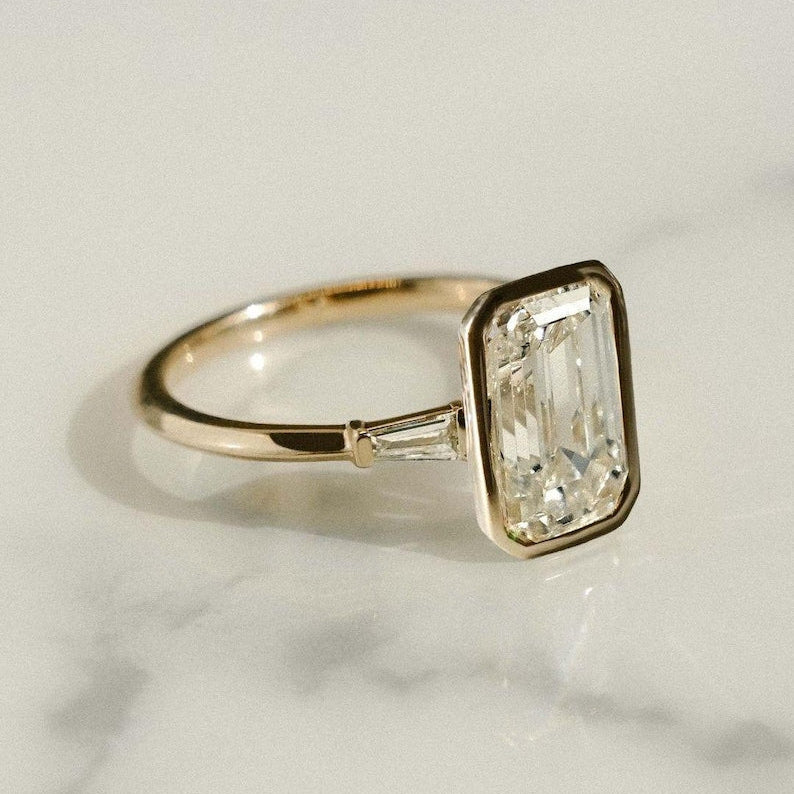 Lab grown 2.5ct emerald diamond ring featuring side tapered accents. A beautiful engagement or bridal ring for the woman you love.