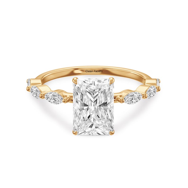 Yellow gold ring featuring lab grown radiant cut diamond with marquise side stone.