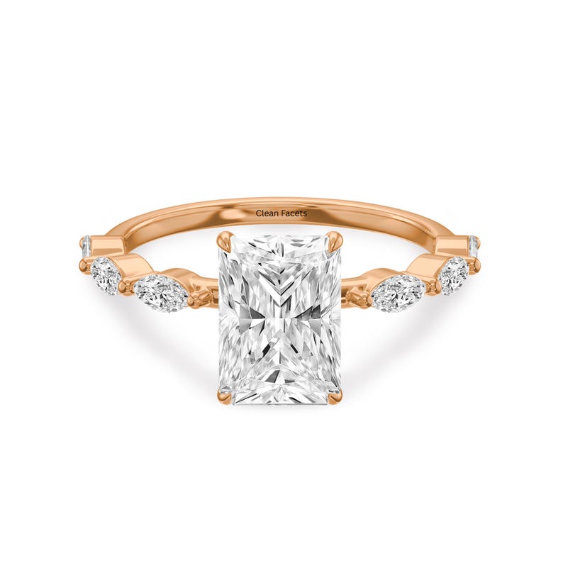Rose gold ring with radiant cut lab grown diamond in center and marquise as side stone.