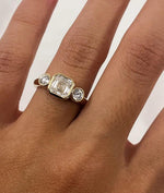 Load image into Gallery viewer, Asscher Cut Trilogy Diamond Engagement Ring featuring a 1.5ct IGI Certified Asscher Cut Lab Grown Diamond with round lab grown diamond side stones in solid gold. Three-stone engagement ring with 1.82ct total carat weight.