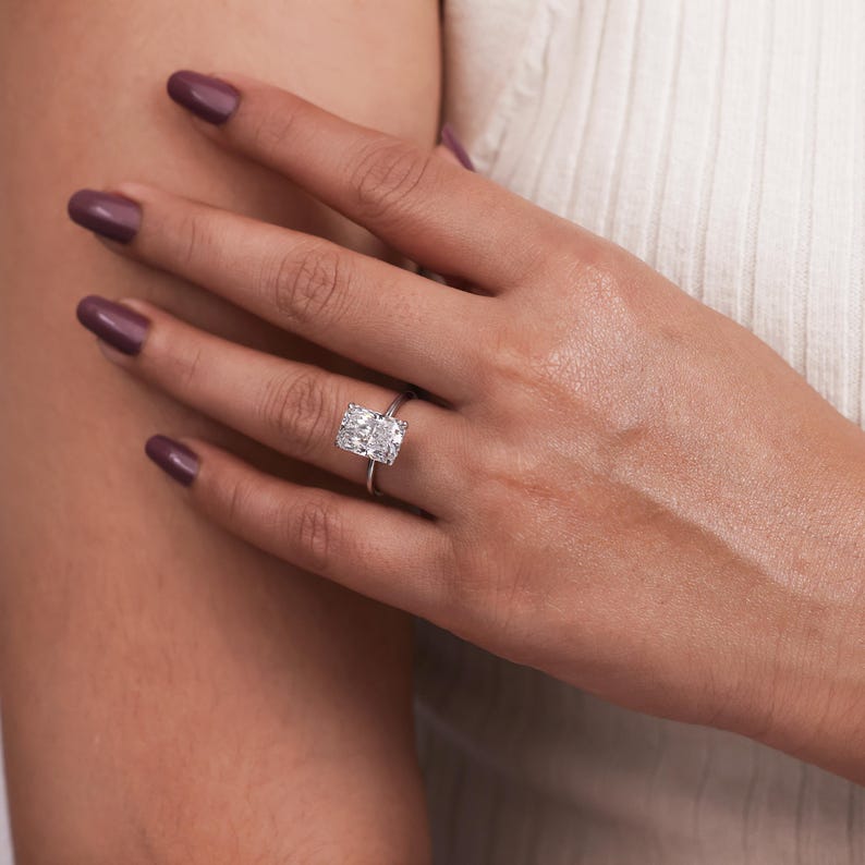 Radiant cut lab grown diamond solitaire engagement ring set in 4 claw prongs crafted in sterling silver.