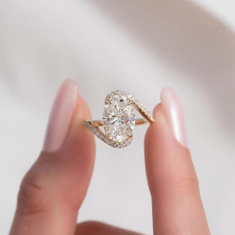 4CT oval cut moissanite engagement ring in 14k yellow gold twisted band.