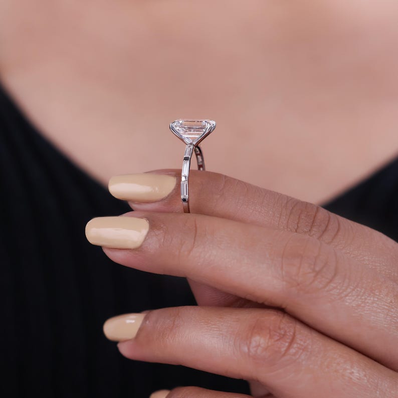Emerald cut diamond engagement ring with baguette side stone.