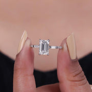 Lab grown emerald cut diamond side stone engagement ring.