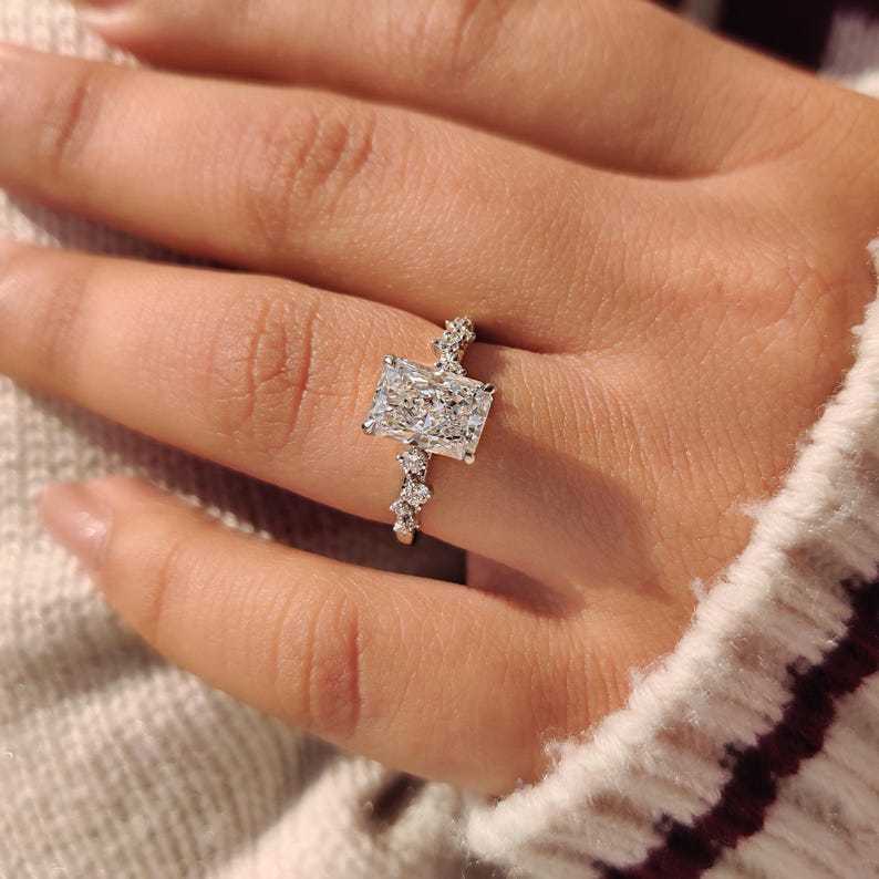Radiant cut lab grown diamond ring with four claw prong setting.